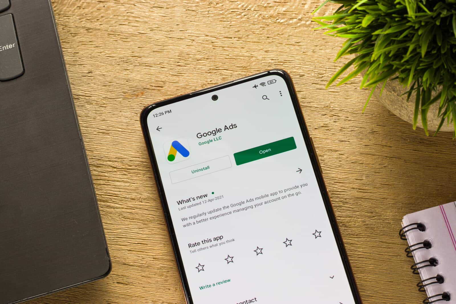 Google adwords on a phone next to a laptop.