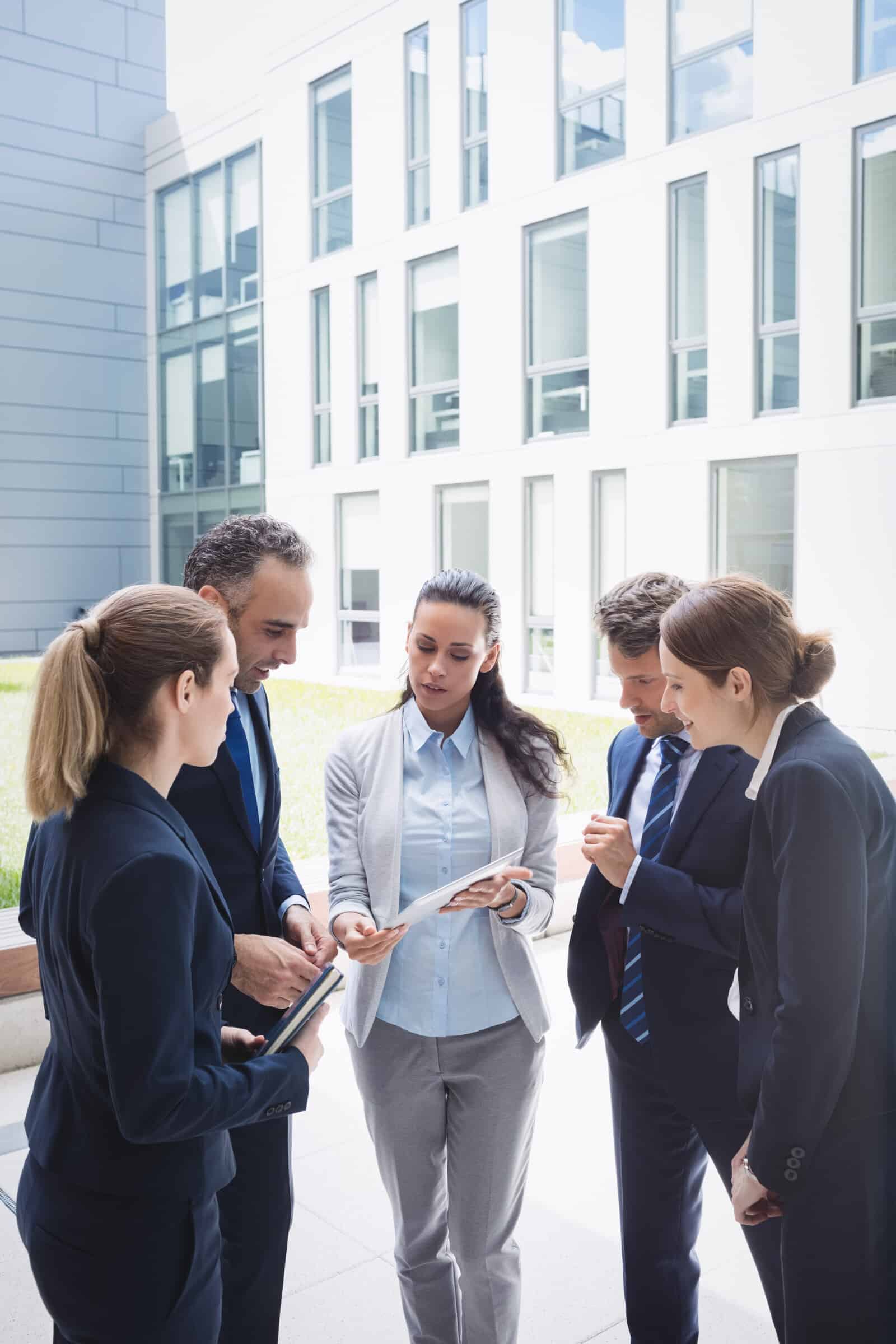 A group of business people looking at a tablet.