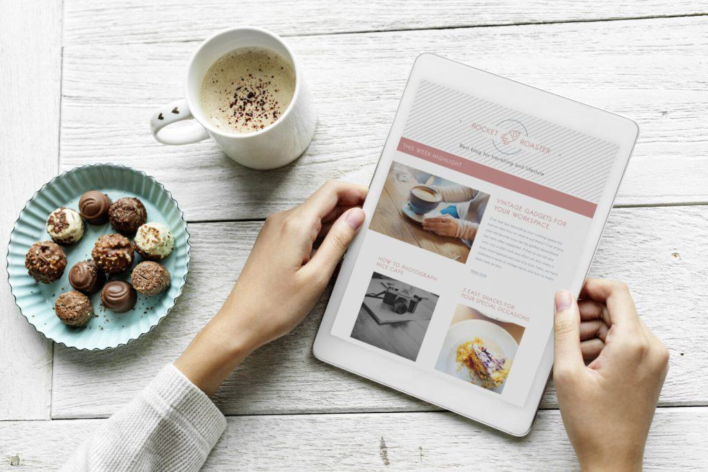 A woman is using an ipad to look at a website.