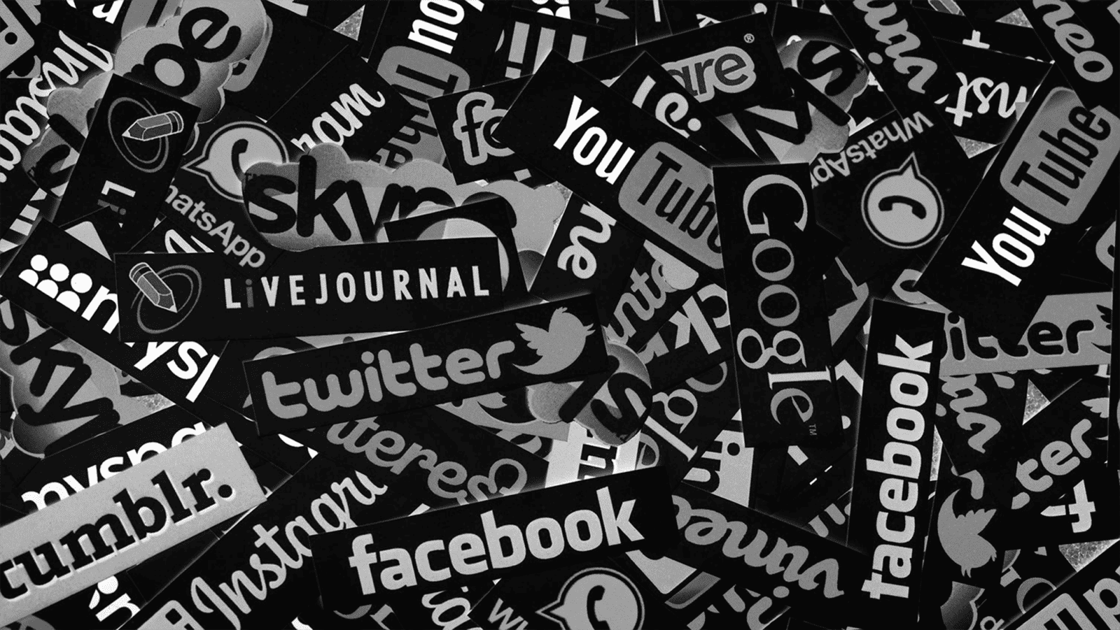 A black and white photo of many social media logos.