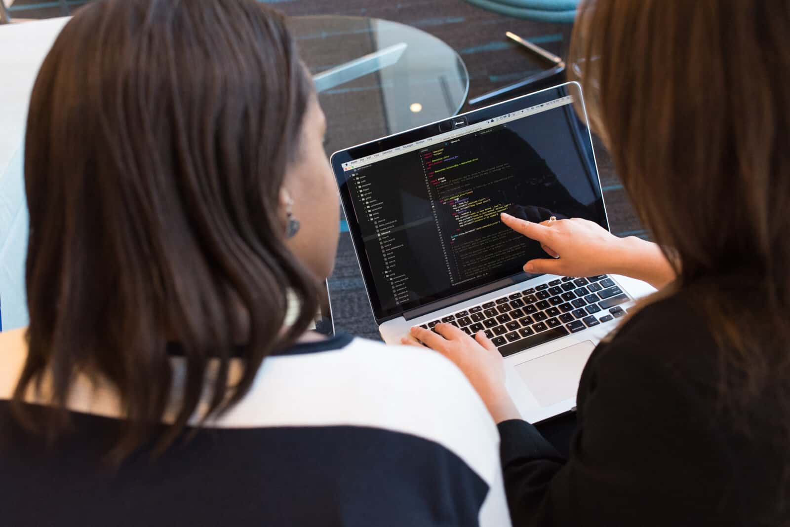 Two women working on a laptop.