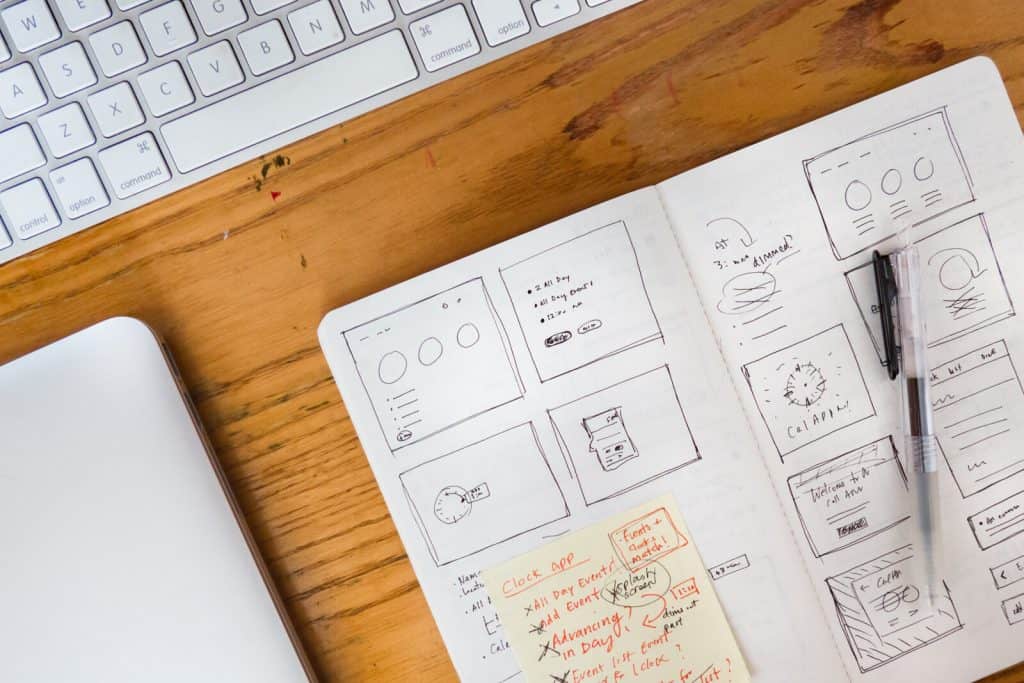 A notebook on a desk with a pen and a keyboard.