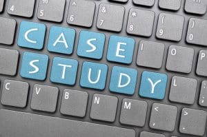 Computer keyboard with gray keys. The phrase "CASE STUDY" is spelled out using blue keys.