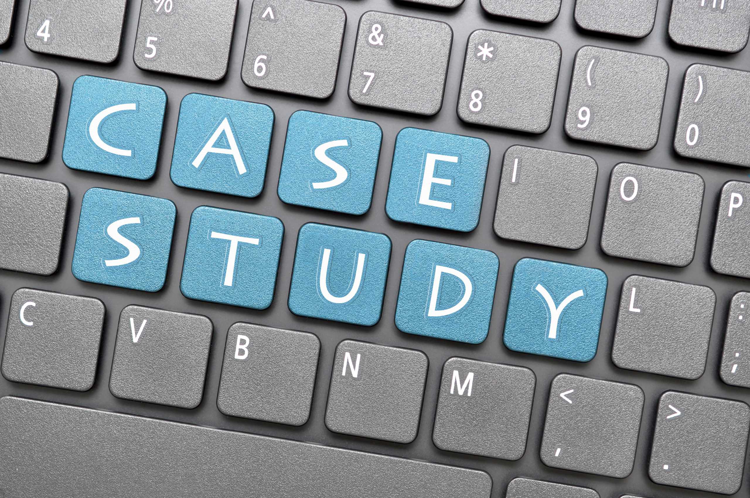 Computer keyboard with gray keys. The phrase "CASE STUDY" is spelled out using blue keys.